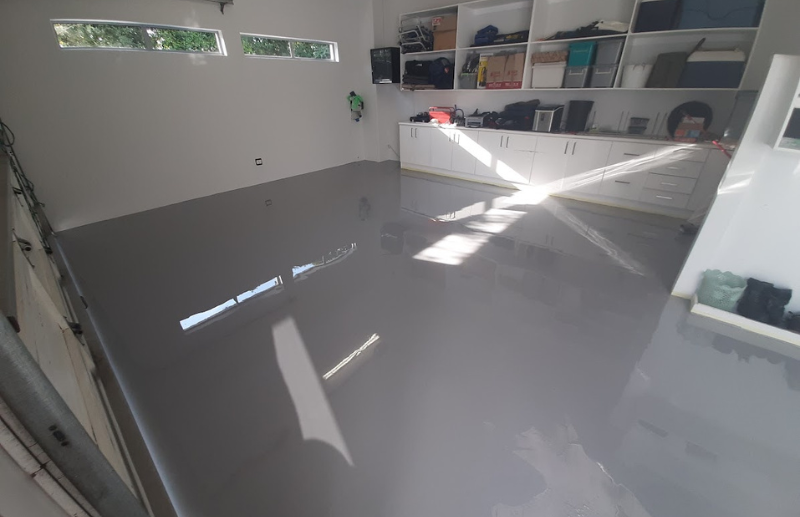Grey epoxy garage floor installation with high-gloss finish